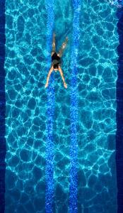 a person swimming in a swimming pool at Mahaloka Valley Nusa Penida in Nusa Penida