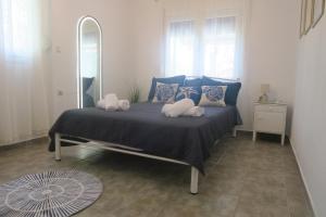 a bedroom with a bed with pillows and a mirror at Efterpi seaside house in Chrysi Ammoudia