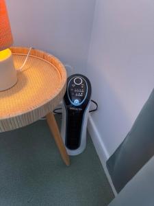 a remote control sitting next to a table at Studio Les écuries de la forêt in Le Buisson Genois