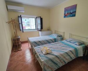 a bedroom with two beds and a window at Casa Spezzara (tra Tropea e Capo Vaticano) in Santa Domenica +35 photos