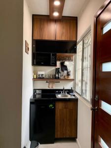 a small kitchen with a sink and a microwave at Loft Residencial Monterrey Norte in Monterrey