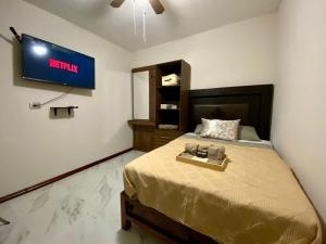 a bedroom with a bed with a television on the wall at Loft Residencial Monterrey Norte in Monterrey