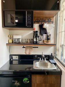 a kitchen with a sink and a microwave at Loft Residencial Monterrey Norte in Monterrey