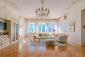 a living room with a couch and chairs and a chandelier at Villa Castiglioni Luxury Apartment in Laglio