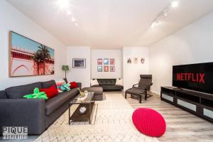a living room with a couch and a flat screen tv at The Obsolete Suite - HotTub - King Bed - AC - Pet Friendly in Edmonton