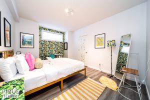 a bedroom with a large bed and a mirror at The Obsolete Suite - HotTub - King Bed - AC - Pet Friendly in Edmonton +100 photos