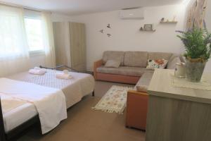 a living room with a bed and a couch at Efterpi seaside house in Chrysi Ammoudia