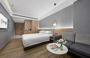a hotel room with a bed and a couch at 夏朗酒店 Xialang Hotel&Free ShuttleBus to Guangzhou BaiyunInternational Airpor in Guangzhou