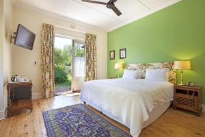 a bedroom with a white bed and a green wall at Medindi Manor in Cape Town +35 photos
