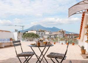 a patio with a table and chairs on a roof at Maison Pompei in Pompei