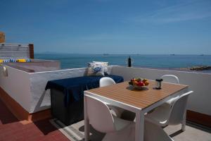 a table and chairs on a balcony with the ocean at Beachfront Apartment - 2 Terraces - Stunning Sunrises in Gibraltar