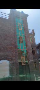 a tall brick building with a basketball hoop in front of it at Srinagar Stay House in Srinagar