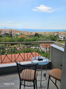 a table and two chairs on a balcony with a view at Moumis Luxury Apartment in Limenaria
