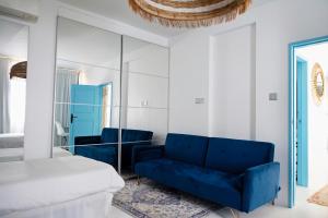 a bedroom with a blue couch and a bed at Beachfront Apartment - 2 Terraces - Stunning Sunrises in Gibraltar