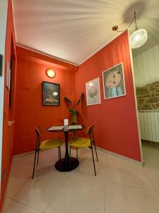 a dining room with a table and chairs against a red wall at Il Cortiletto in Rocca Cilento
