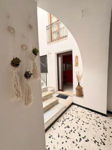 a room with white walls and a staircase with plants on the wall at Il Cortiletto in Rocca Cilento