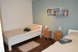 a small room with two beds and a shelf at Ferienwohnung Carlo in Bindlach +37 photos
