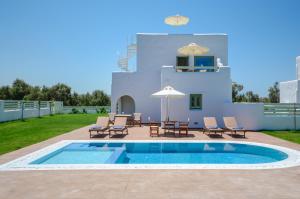 a pool with chairs and a table and an umbrella at My Villa Naxos in Naxos Chora