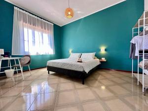 a bedroom with a bed and a blue wall at Maison Pompei in Pompei