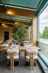 a dining room with tables and a tree at Campeador Expo in Bucharest