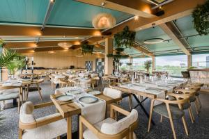 a restaurant with wooden tables and chairs and windows at Campeador Expo in Bucharest
