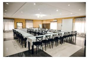 a conference room with tables and chairs and a screen at Leon's Lodge in Choma