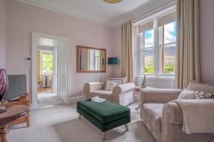 a living room with a couch and chairs and a tv at Cameron Fell Apartment Keswick at The Lairbeck in Keswick