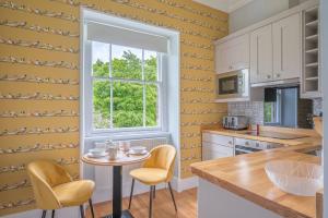 a kitchen with a table and chairs and a window at Cameron Fell Apartment Keswick at The Lairbeck in Keswick