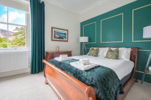 a bedroom with a large bed with green walls at Cameron Fell Apartment Keswick at The Lairbeck in Keswick