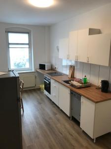 a kitchen with white cabinets and a wooden counter top at Arnold Apartments in Glauchau