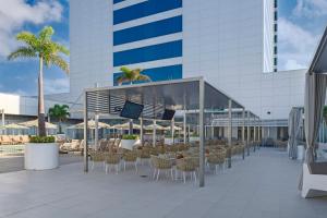 a patio with chairs and tables and a building at Riu Plaza Guadalajara in Guadalajara