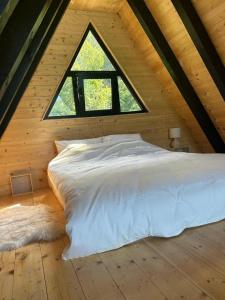 a bed in a wooden room with a window at Omorika Perućac Splav in Gaočići