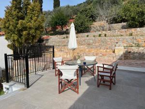 a patio with a table and chairs and an umbrella at Olive Hill in Ancient Epidauros +91 photos