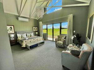 a large bedroom with a bed and two chairs at Greens & Dreams in Parys +17 photos