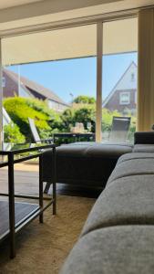 a living room with a couch and a large window at Nord Loft in Langeoog