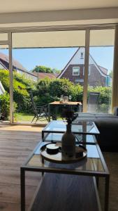 a glass coffee table in a living room with a large window at Nord Loft in Langeoog