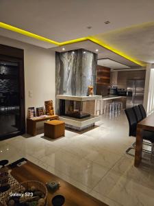 a living room with a fireplace and a kitchen at Moumis Luxury Apartment in Limenaria
