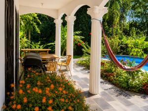 a patio with a table and chairs and flowers at Villa Sulterra in Tambor