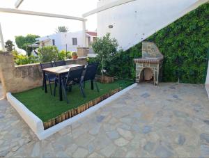 a patio with a table and chairs and a fireplace at Pefkos Sea Shell in Pefki