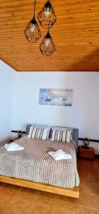 a bedroom with a bed and a wooden ceiling at Pefkos Sea Shell in Pefki +4 photos