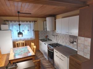 a kitchen with white cabinets and a table and a stove at Počitniška hiška Kašta in Luče