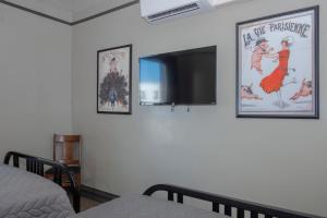 a bedroom with two posters on the wall and a television at Gardner Hotel & Hostel in El Paso