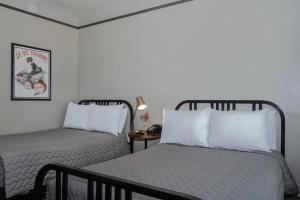 a bedroom with two beds and a table with a lamp at Gardner Hotel & Hostel in El Paso