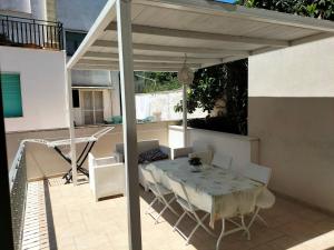 a patio with a table and chairs under a pergola at Casa Vacanze " ORTE " in Otranto