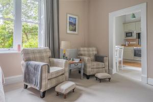 a living room with two chairs and a table at Bethby Beck Apartment Keswick at The Lairbeck in Keswick
