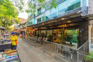 a man is standing in front of a store at Hotel Villa Real 70 Laureles in Medellín