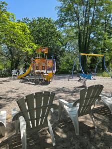 a park with two chairs and a playground at Iscles 231- MH Au calme près du lac in La Roque-dʼAnthéron