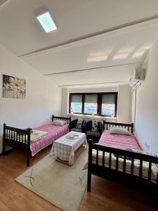 a bedroom with two beds and a living room at Apartman Stankovic in Pirot