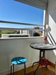 a table and two stools in front of a window at Apartman Stankovic in Pirot
