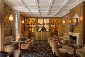 a bar in a restaurant with tables and chairs at Le Pavillon de la Reine & Spa, Place des Vosges in Paris
